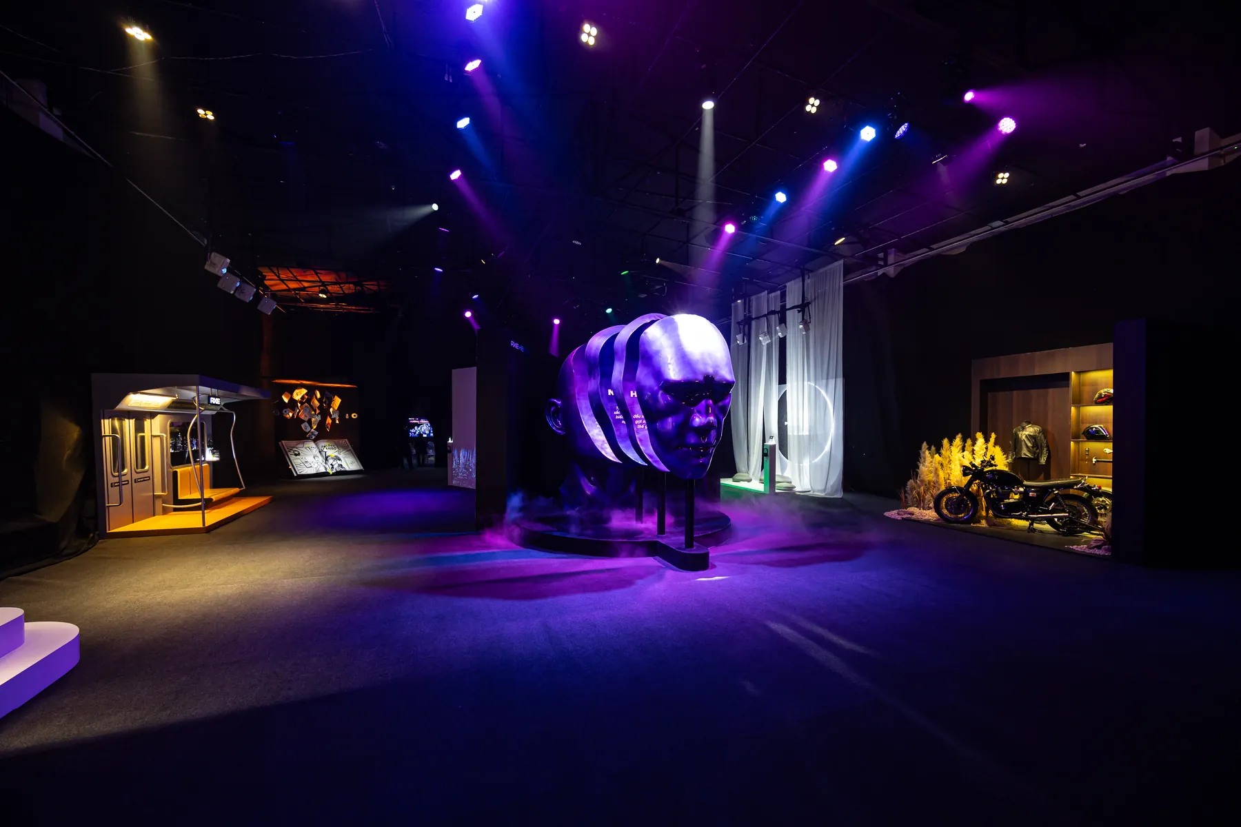 Toàn cảnh triển lãm AXEHIBITION với khối điêu khắc đầu người ở trung tâm